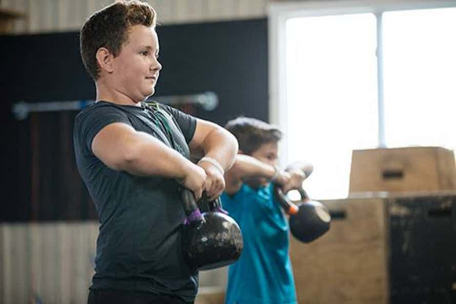 Kids lifting kettlebells to test muscular strength